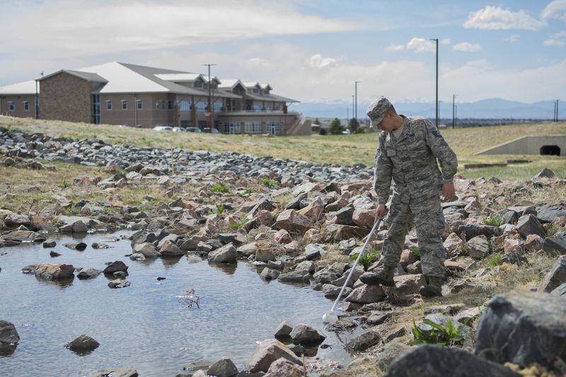 Tech. Sgt. Anthony Santiago, 460th Civil Engineer Squadron pest management NCO in charge, inspects stagnant water for po